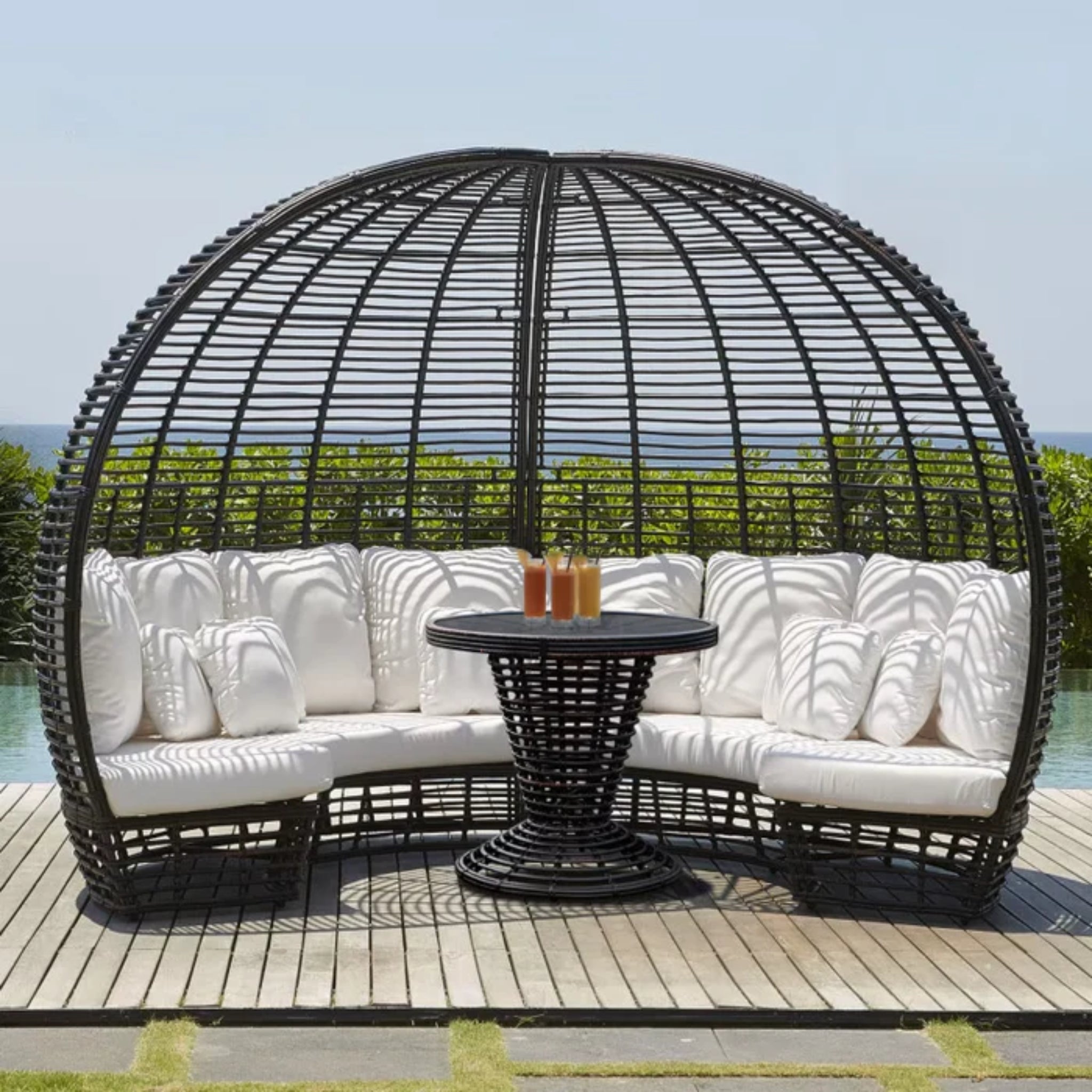 Skyline Design Nexus outdoor daybed with woven fiber cushions and matching table in mushroom finish, ideal for patio lounging