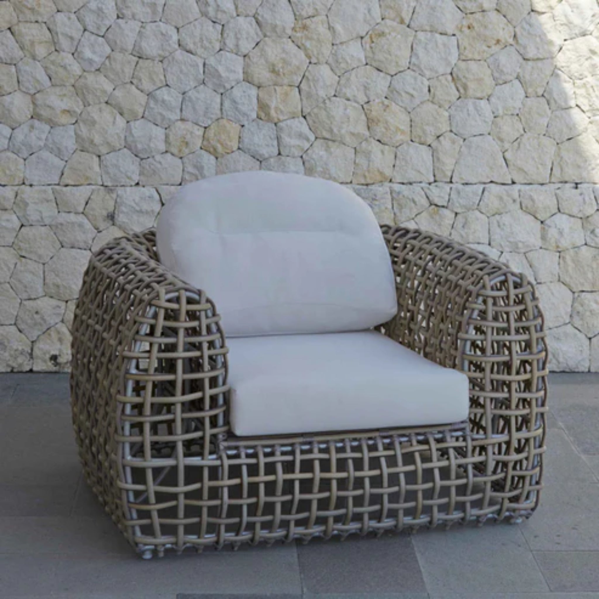 Skyline Design Dynasty outdoor lounge chair with mushroom-colored woven fiber, patio armchair for relaxing outdoor seating.