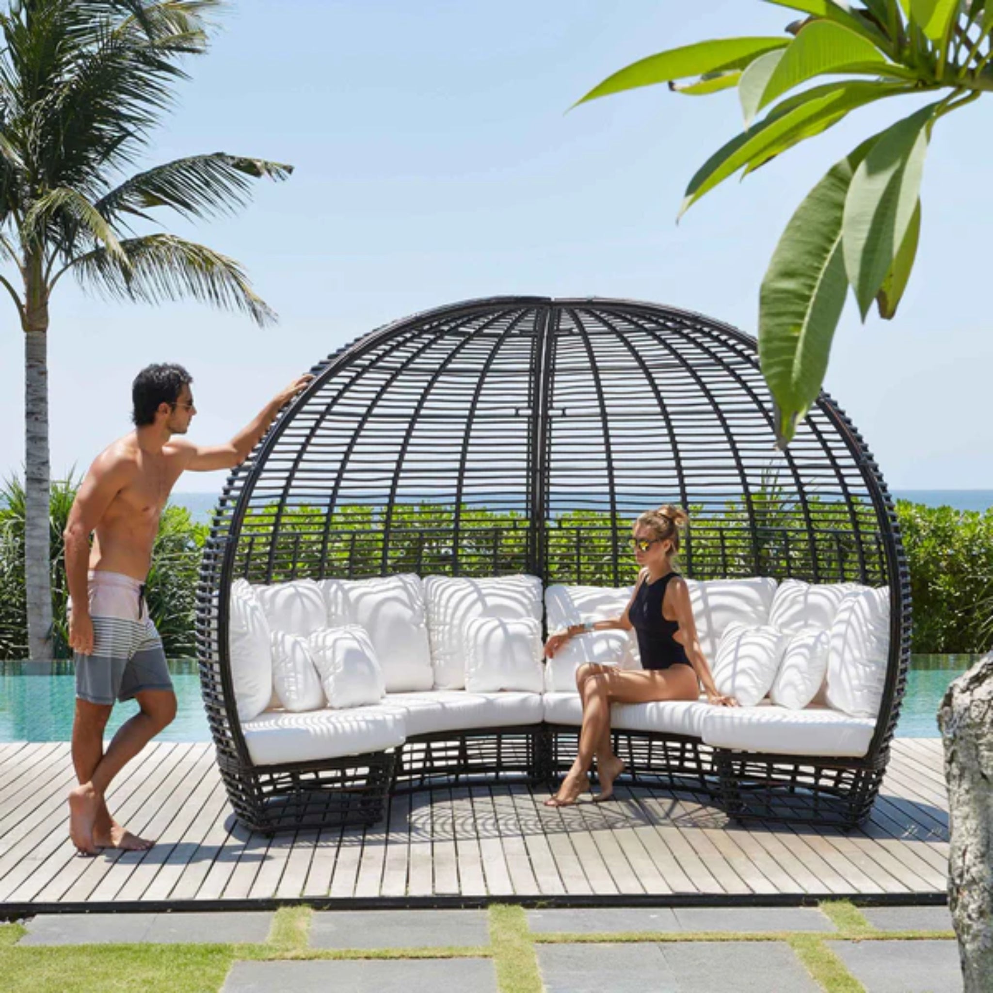 Skyline Design Nexus outdoor daybed with woven fiber in mushroom finish, featuring a side table for patio lounging.