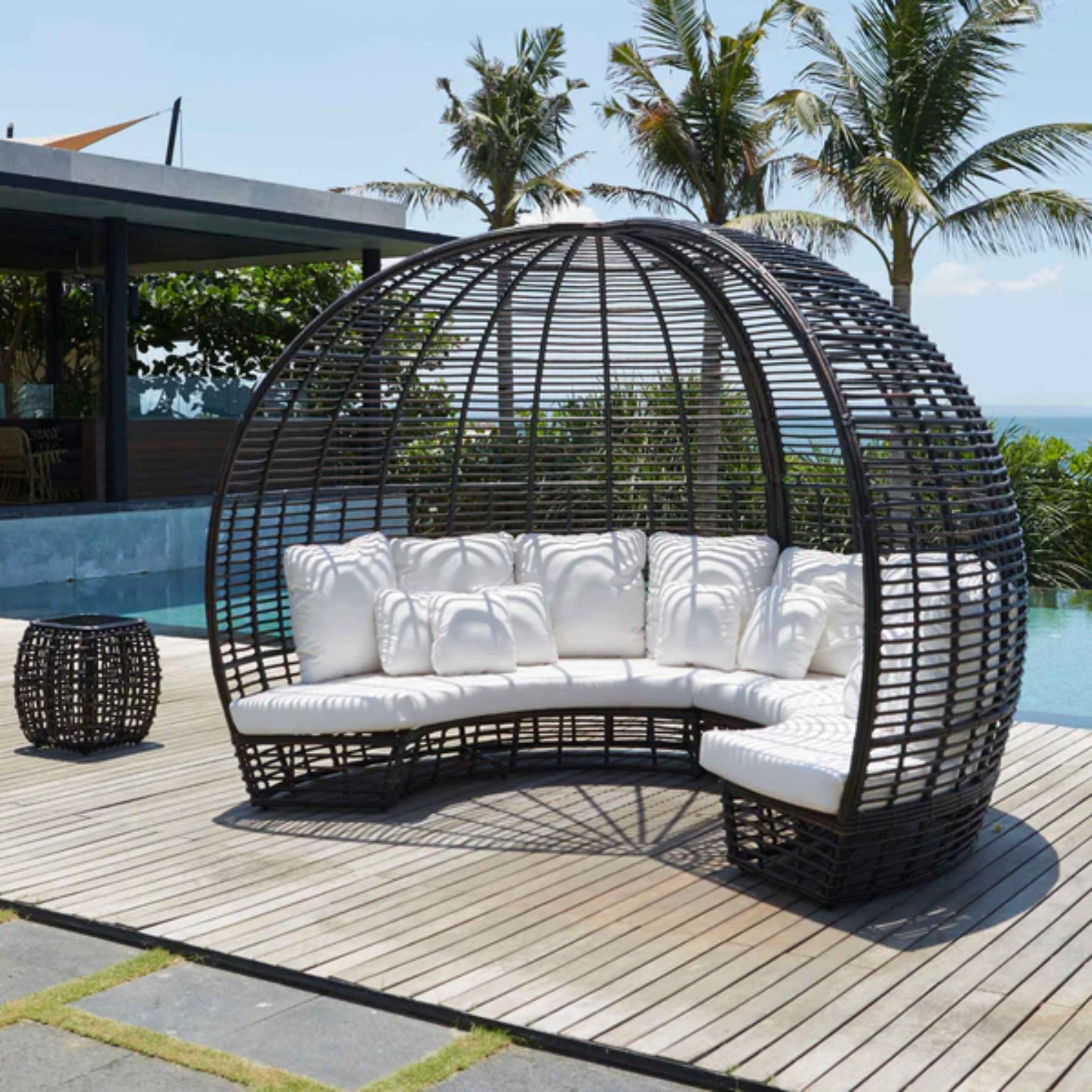 Skyline Design Nexus outdoor daybed with woven fiber in mushroom finish, includes a matching side table for patio relaxation.