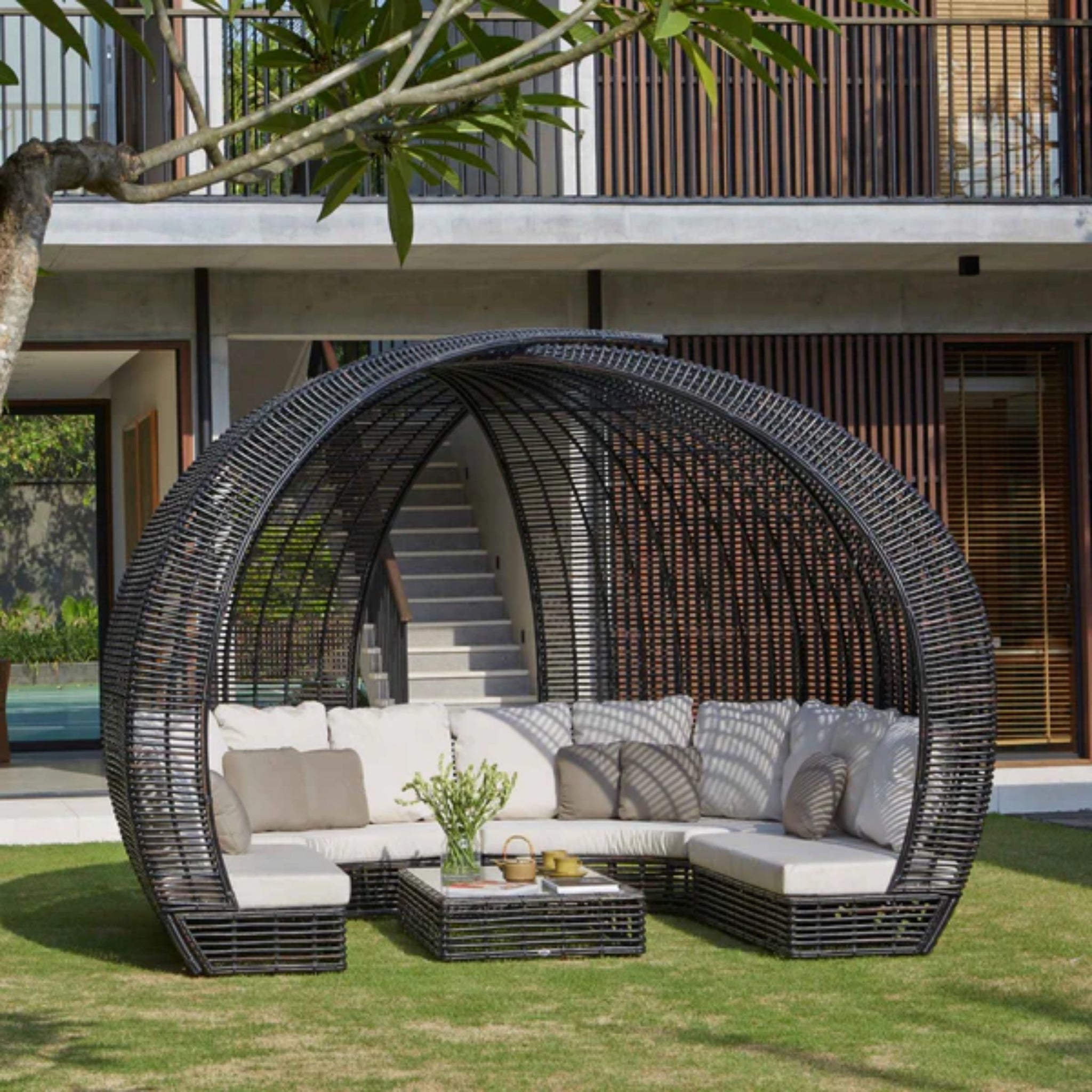 Skyline Design Sparta outdoor daybed with woven fiber in mushroom finish, featuring plush cushions and a stylish patio design.